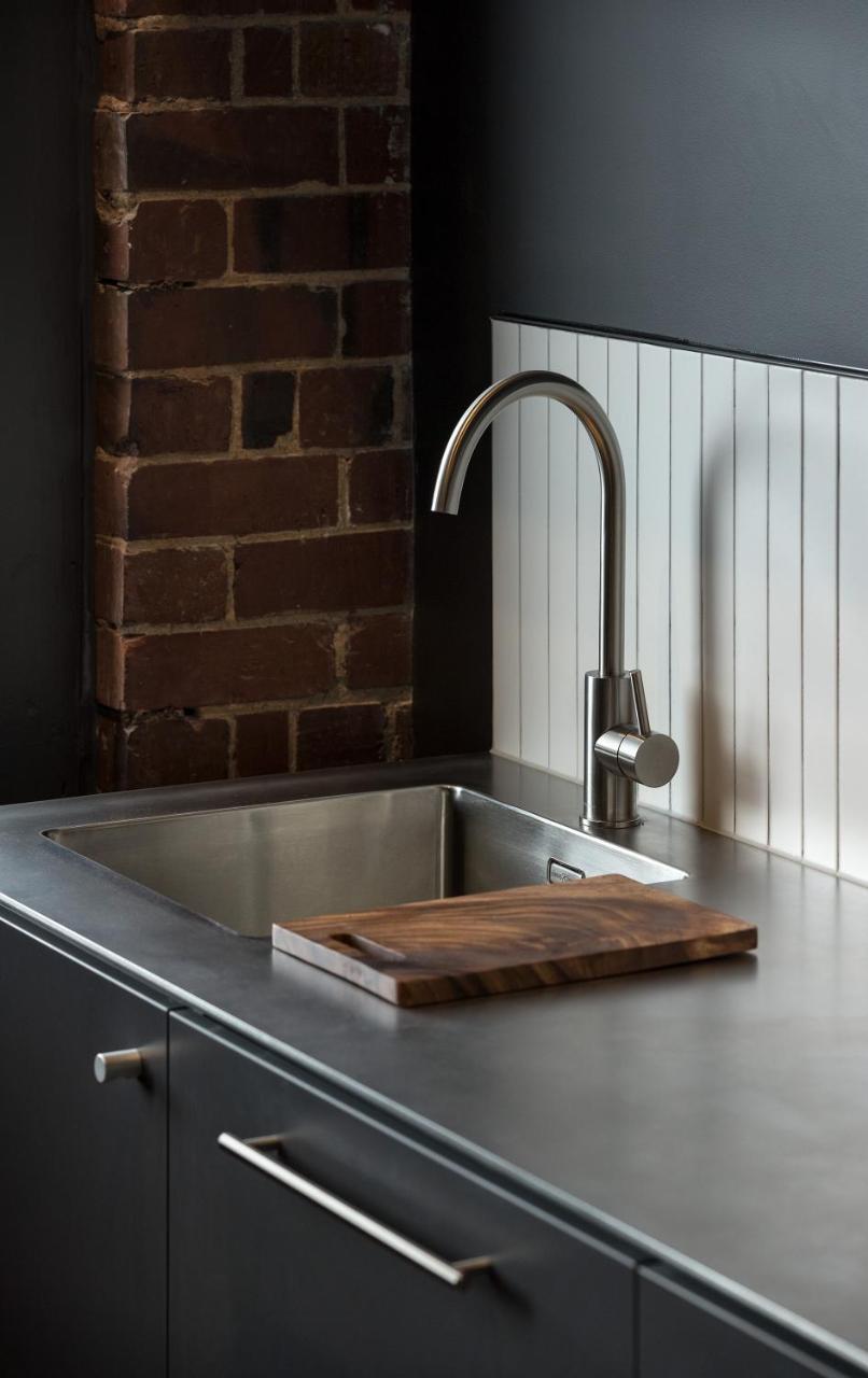 Отель The Chamberson Дьюндин Экстерьер фото A kitchen sink with a wooden cutting board